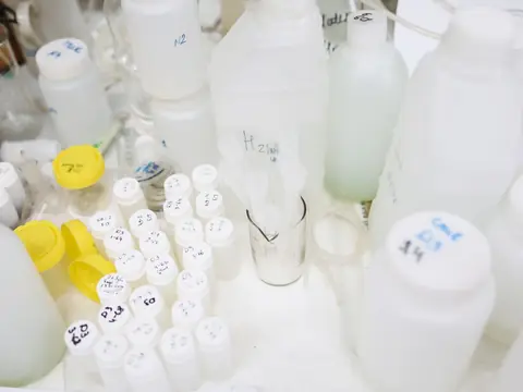 White sample bottles lined up at a lab