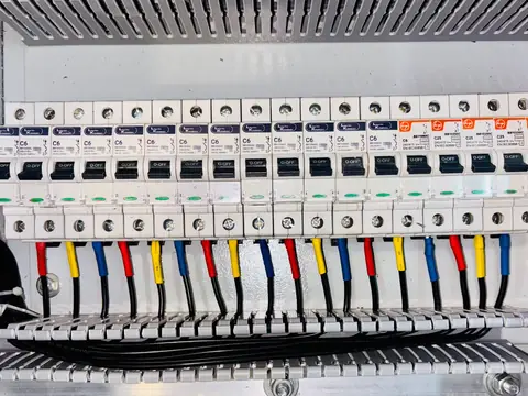 A row of circuit breakers in an open breaker panel