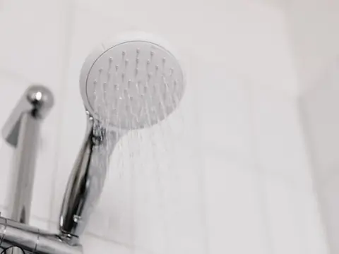 A hand shower running with a full spray of water