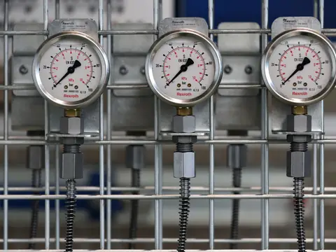 Three pressure gauges mounted on a rack of water lines